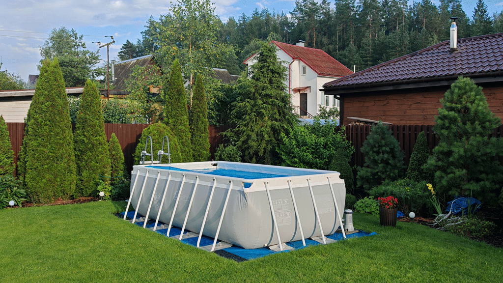 Propriétaire mesurant l'espace jardin pour installation piscine tubulaire